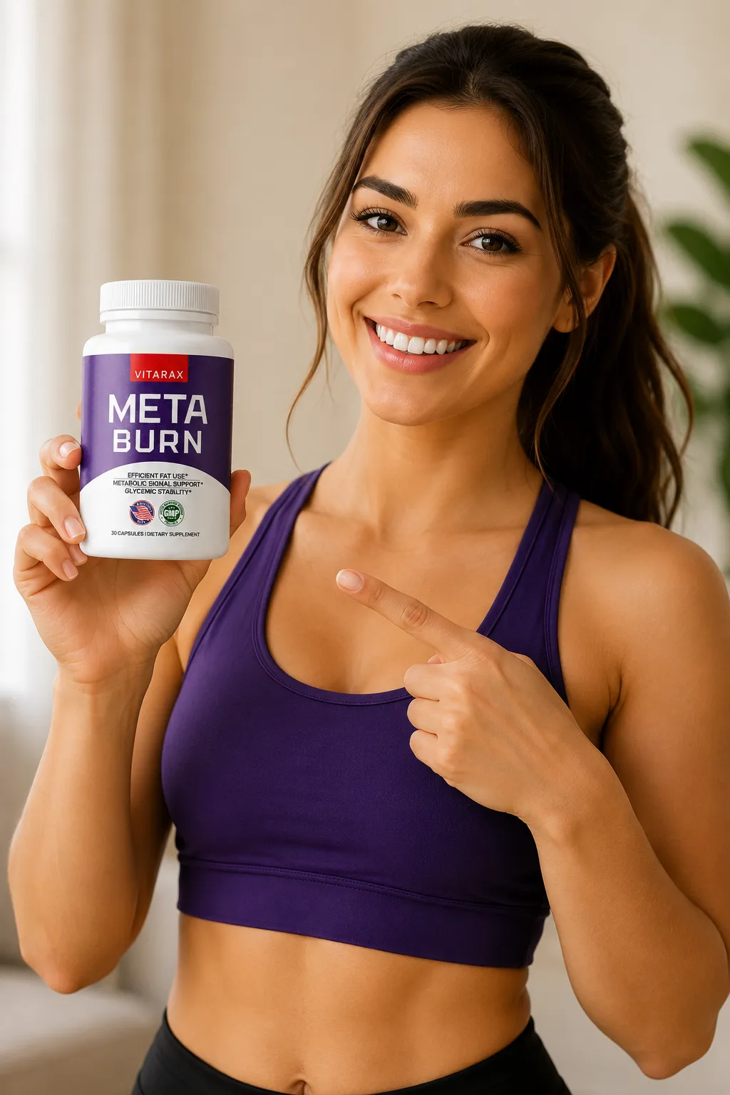 'A vertical image of a smiling young woman in athletic wear holding up and pointing to a bottle of Vitarax MetaBurn dietary supplement.'